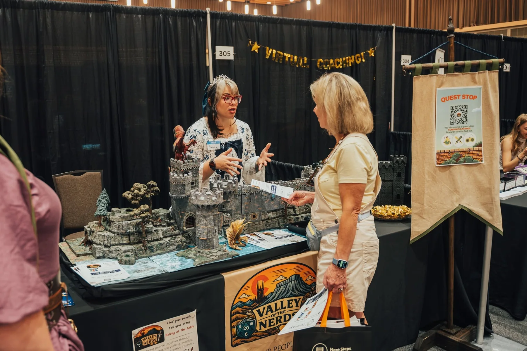 Randie speaking with a community visitor at a Valley of the Nerds event booth.
